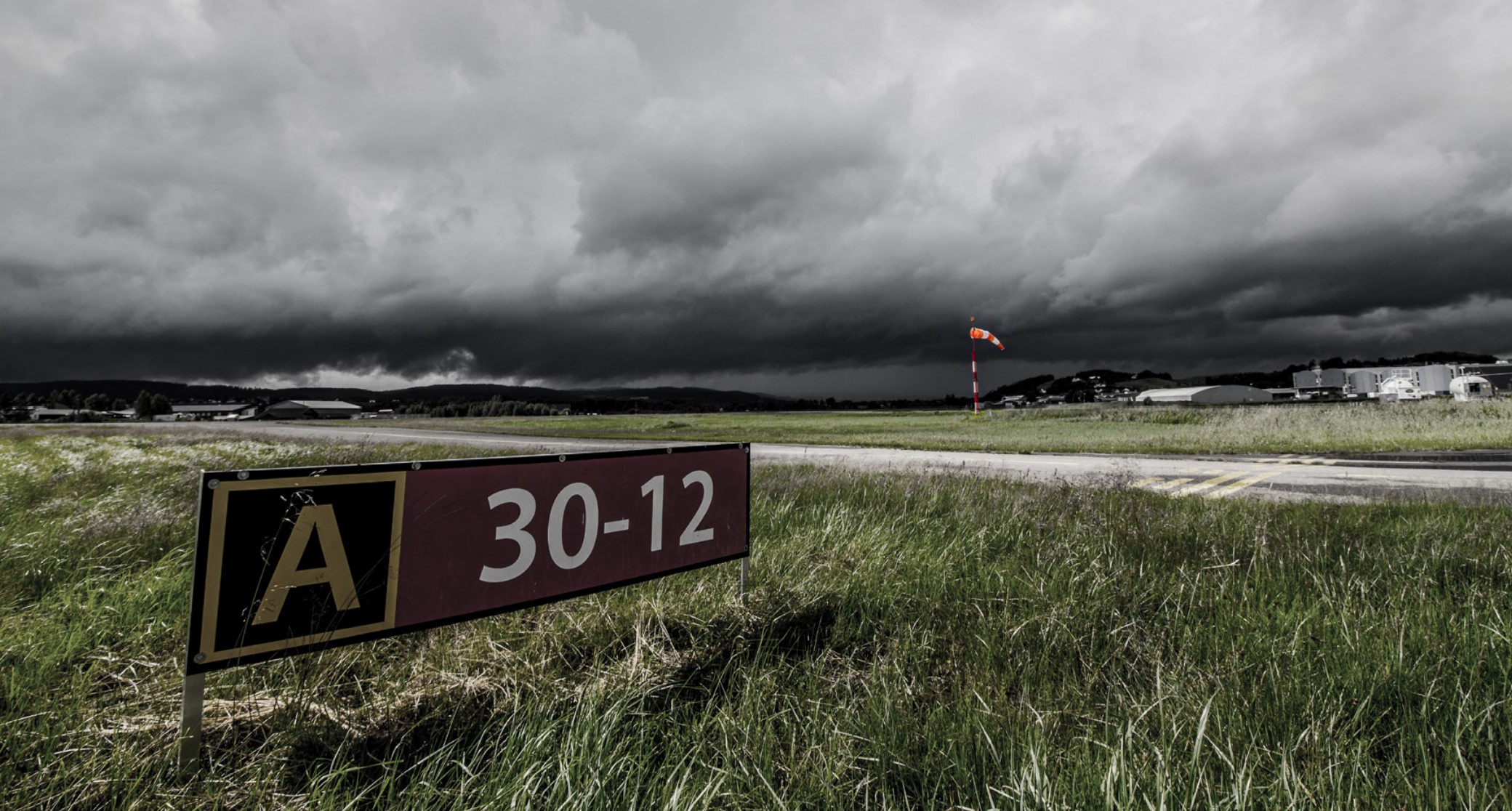Stormy clouds over an airport and runway.