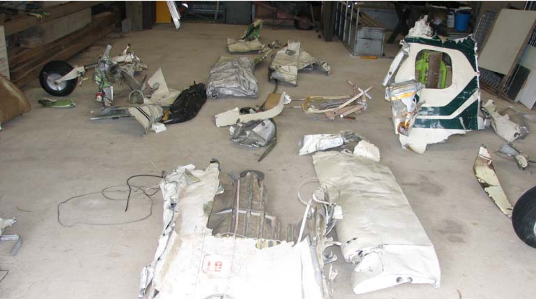 Aircraft wreckage on a hangar floor.