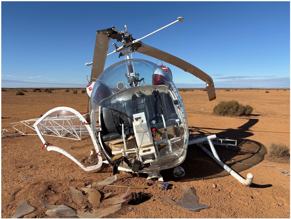 Bell 47 picture taken from in front of helicopter after landing, with broken right skid and ruptured windscreen bubble.