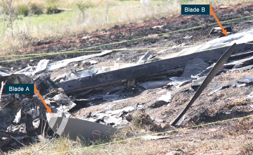 Image of two propeller blades at the accident site sticking out of the ground showing no rotational damage. 