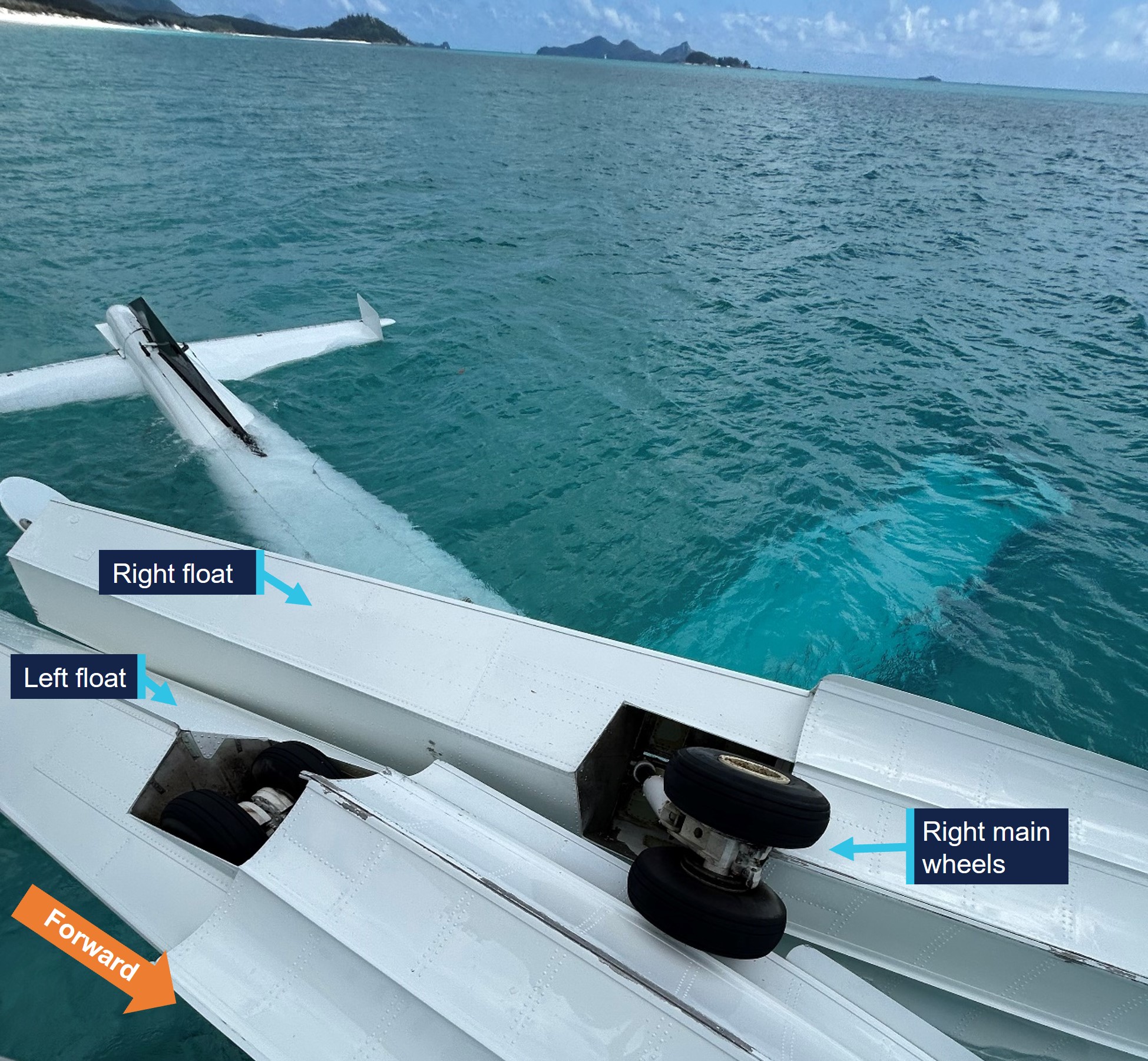 Image of overturned aircraft, post-accident, showing left main gear retracted into the float and right main gear extended.