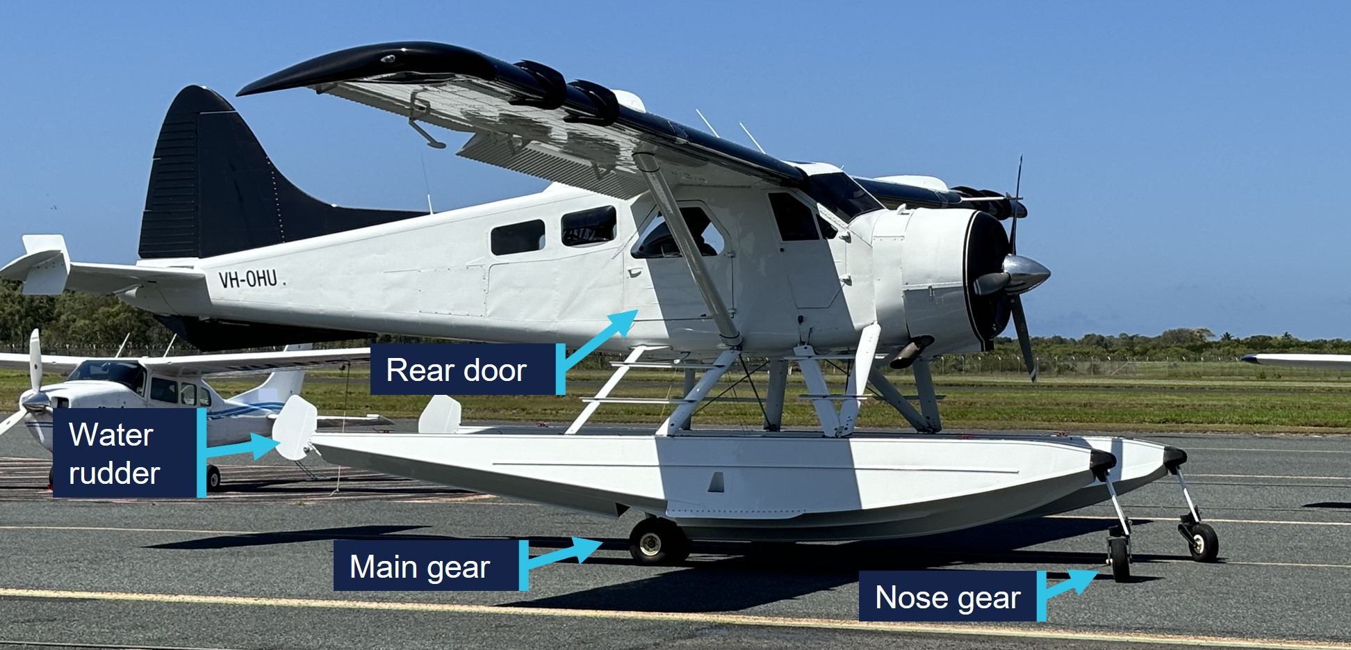 VH-OHU parked at an airport, showing amphibious float and landing gear components.
