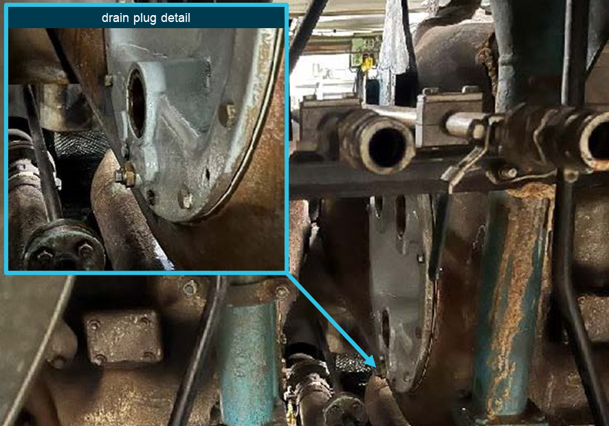 View of the area between the A and B turbochargers on the back-end of the engine. Insert detail photo showing the drain plug at the bottom of the cover.
