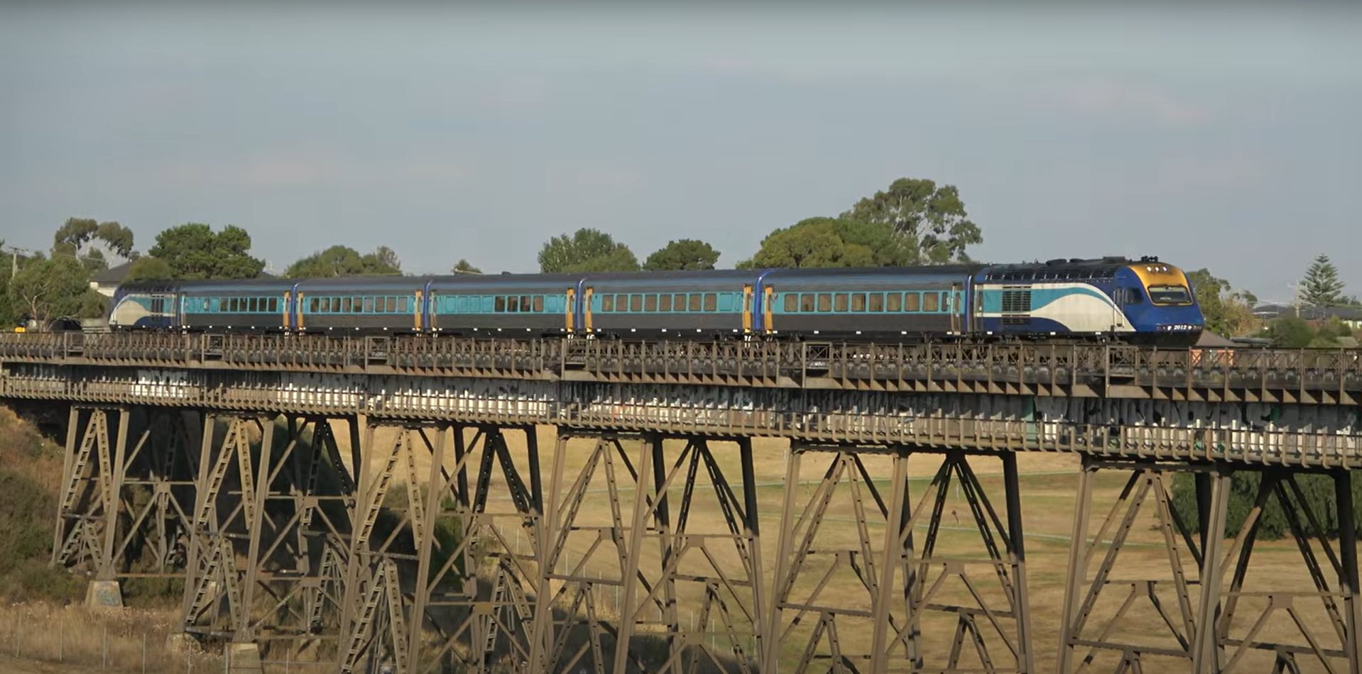 A NSW TrainLink XPT train travels across the Moonee Ponds Creek Bridge