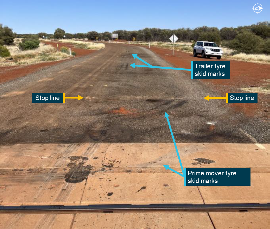 Faded stop line at the level crossing with skid marks evident from the emergency braking of the truck