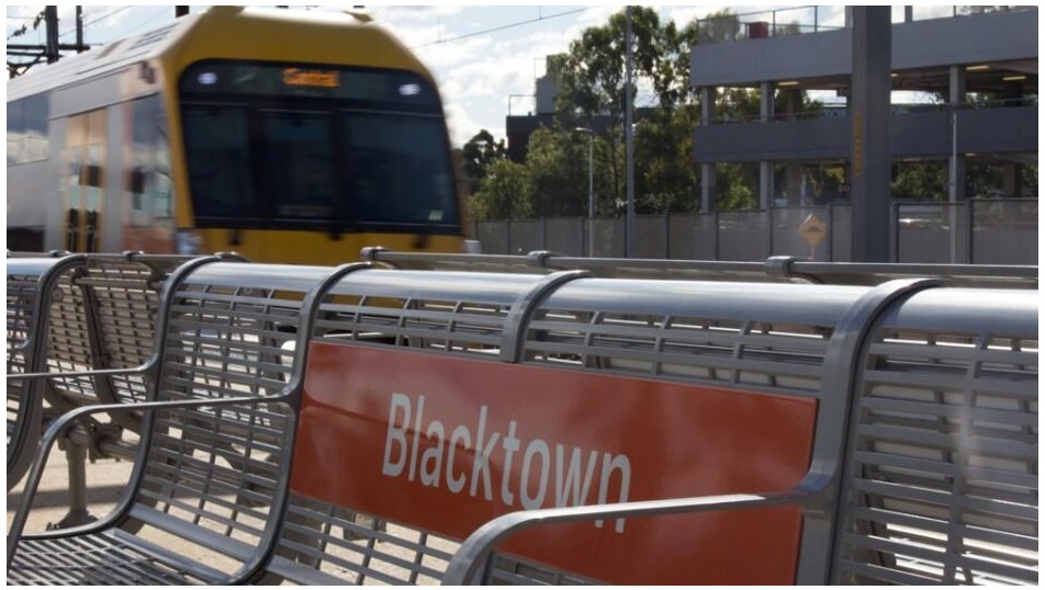 A train passing in the background of a bench at Blacktown Station. Source: Transport for NSW