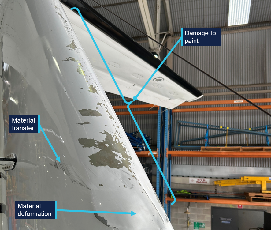 A photograph of the right side of the empennage, showing paint damage, deformation and some material transfer.