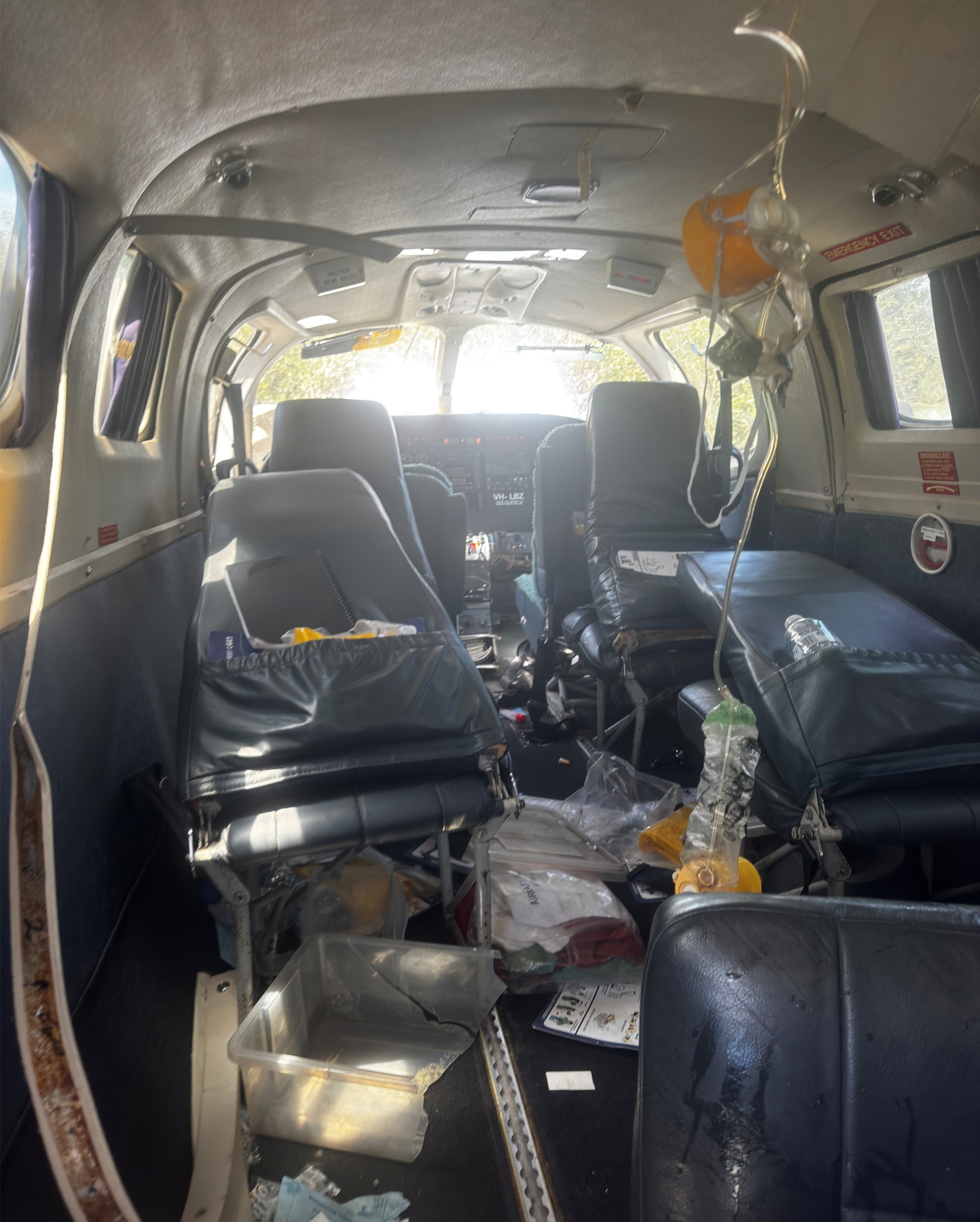 Inside of the aircraft cabin showing substantial damage to seats, and oxygen masks deployed. 
