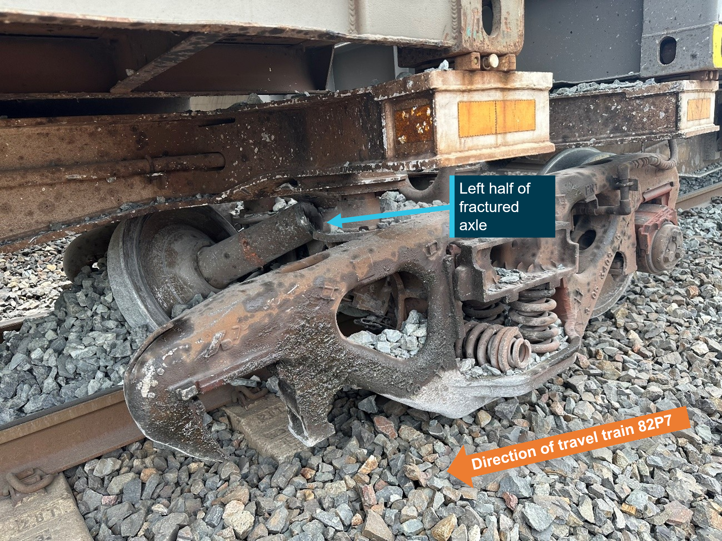 Photograph of damaged bogie under train 82P7 with half of fractured axle attached.