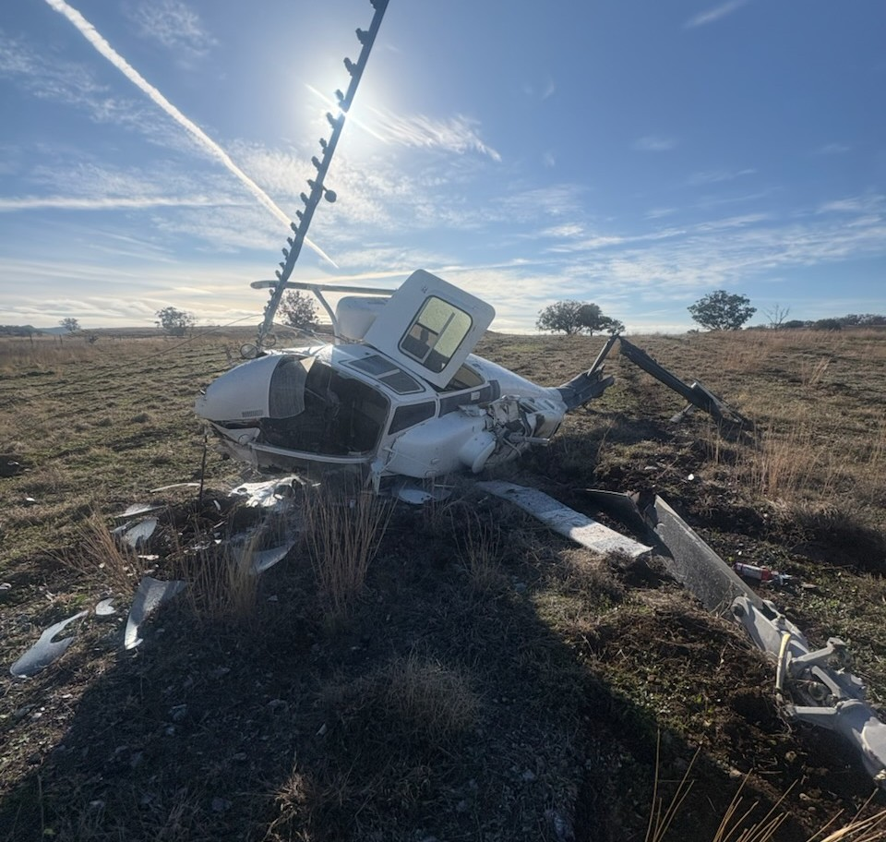Image of the helicopter after colliding with the ground, showing substantial damage to the airframe.
