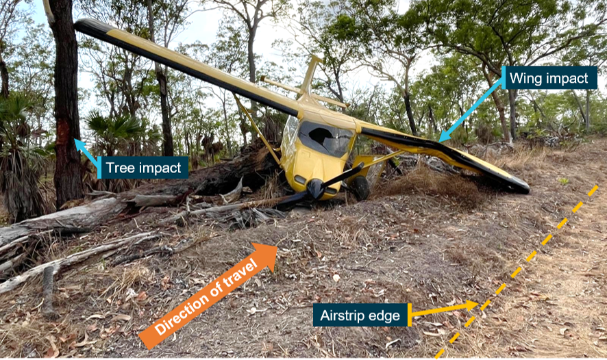 Photograph of the aircraft following the collision, showing impact damage to the wing and tree.
