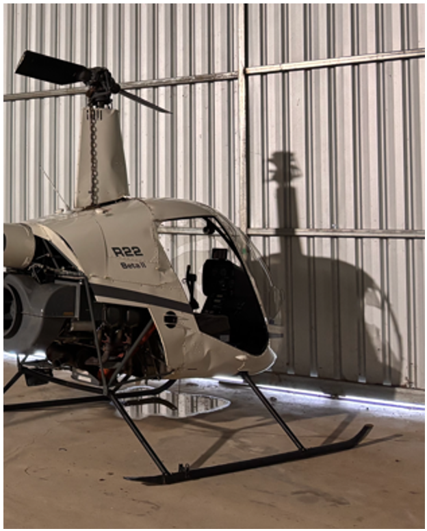 Picture of damaged helicopter in hangar post-accident.
