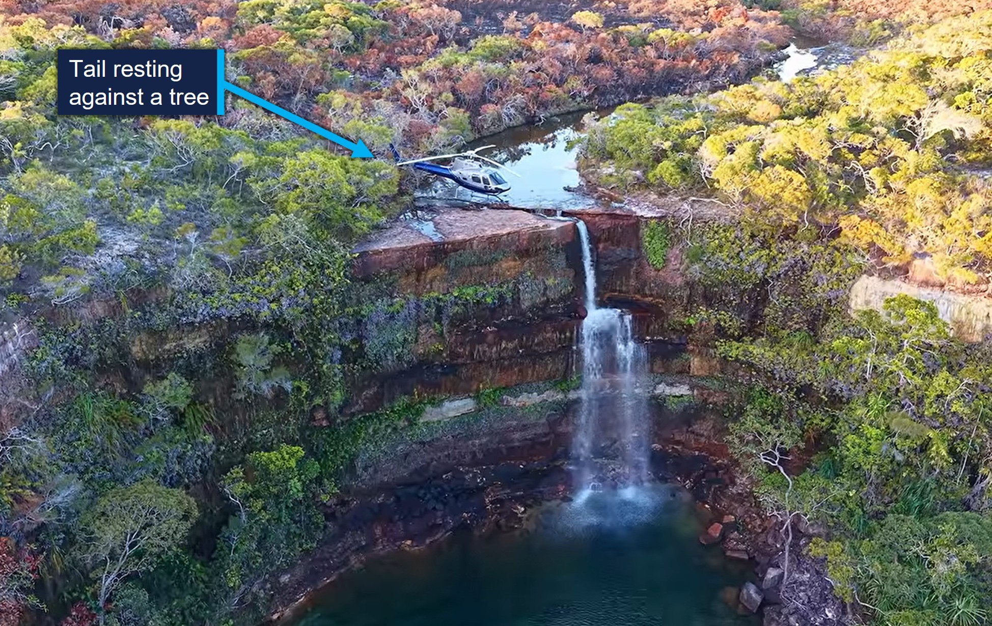 This is an aerial view looking south towards the helicopter at the top of the waterfall. A label points out the tail is resting against a small tree.