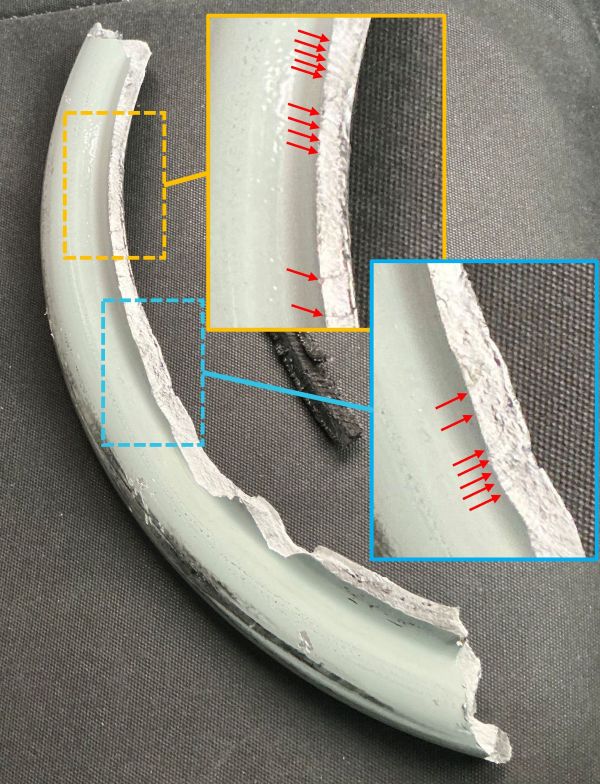 Close up of the separated wheel section with magnified areas of the fracture surface showing concentric ring features.