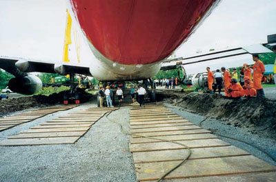 gravel road constructed below ground level beneath Qantas B747-400 VH-OJH