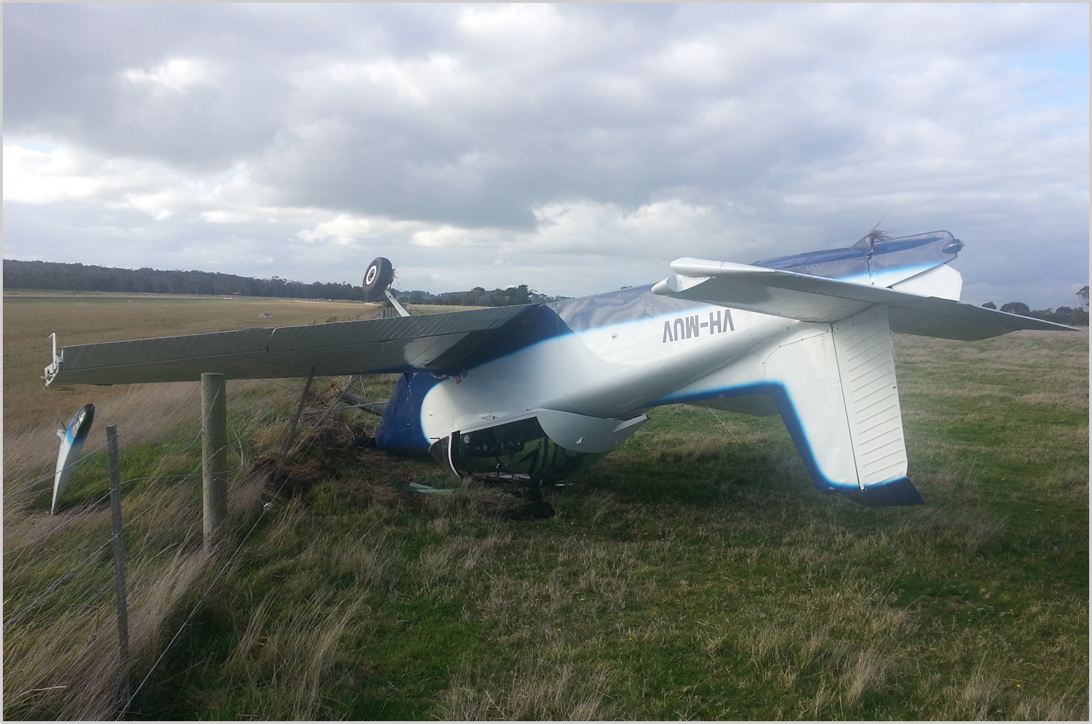 Figure 1: VH-MUV inverted after flipping over the airport perimeter fence