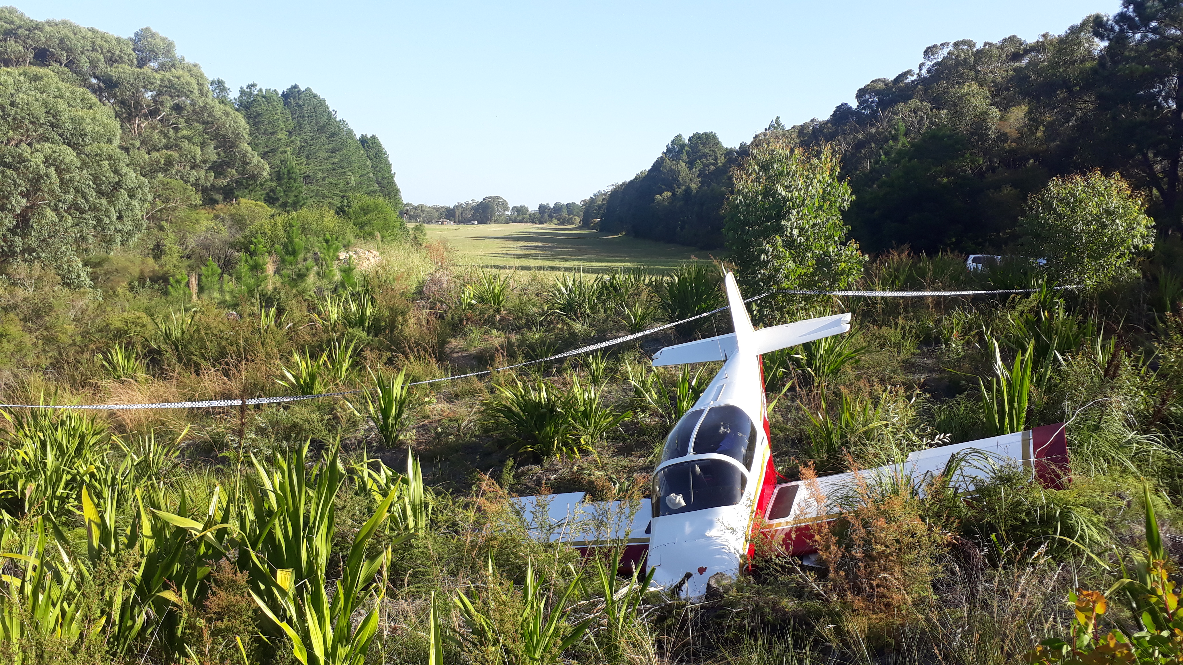 Figure 2: View of the accident site showing VH-OAJ, looking back along the runway. Source: ATSB