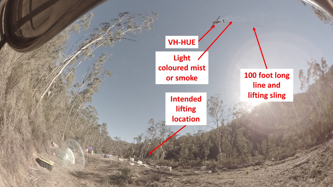 Figure 2: Light coloured gas or mist from helicopter prior to accident. A light coloured mist or smoke is visible trailing from the helicopter in this photograph taken near the time of the ‘Mayday’ call. Source: GHD.