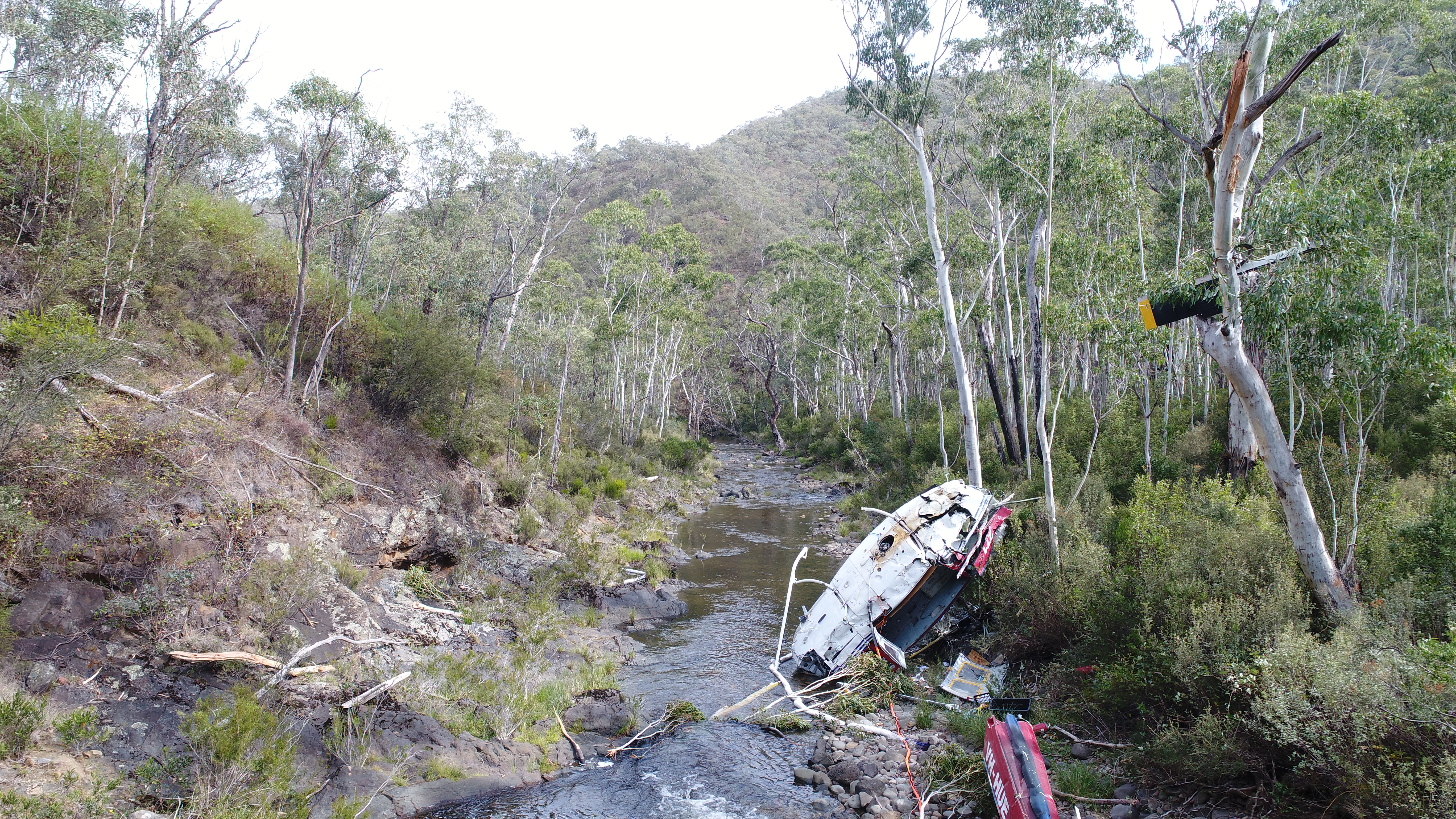 Figure 4: Helicopter wreckage in Yarrangobilly River. Wreckage of VH-HUE looking downstream away from the drill pad, in the approximate direction of flight. Source: ATSB