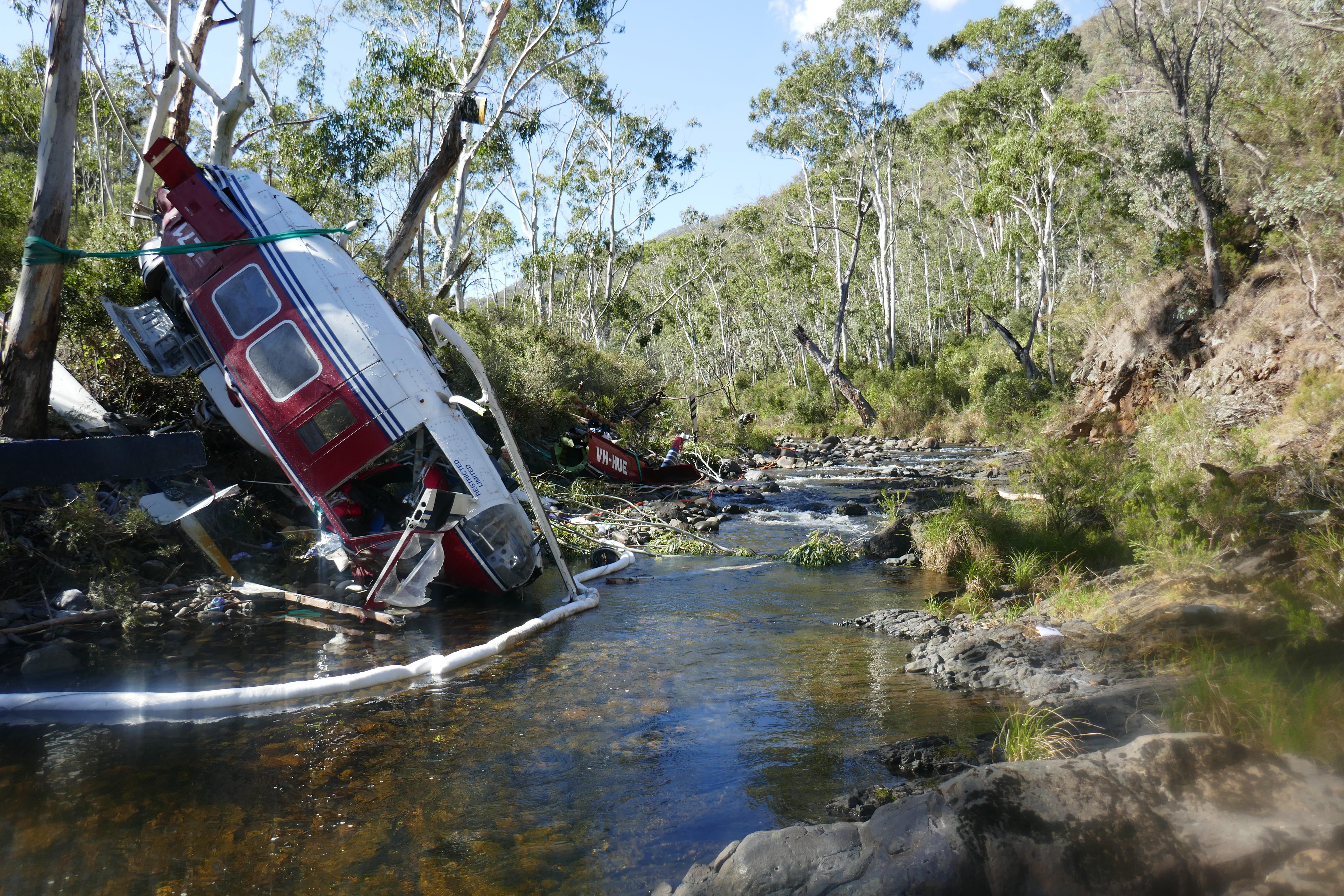 Figure 5: Helicopter wreckage showing nose of helicopter in Yarrangobilly River. Wreckage of VH-HUE looking upstream toward the drill pad, showing the nose of the helicopter and pilot’s seat. Source: ATSB