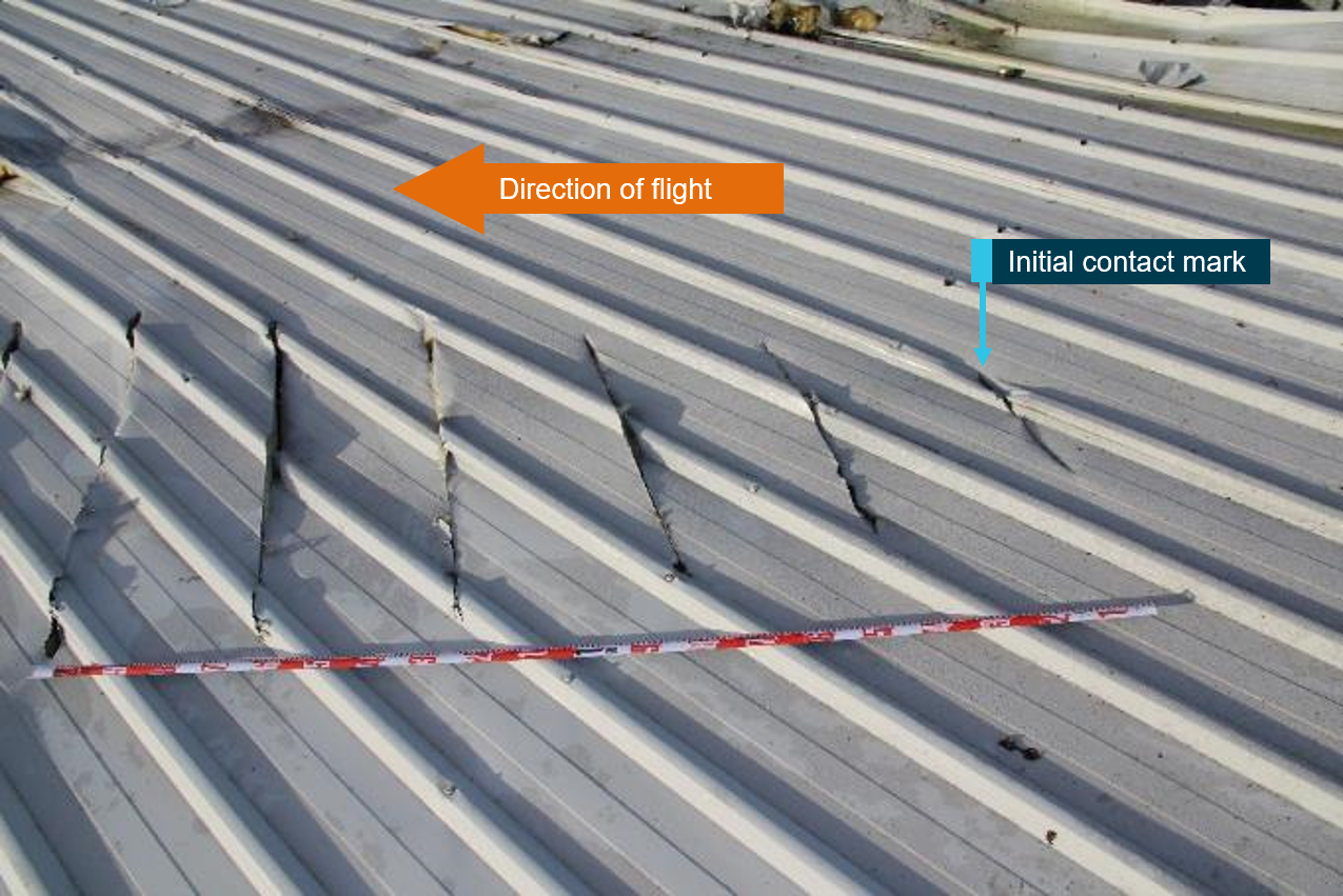 Figure 27: Left propeller slash marks in roofing material with tape measure showing distance between cuts