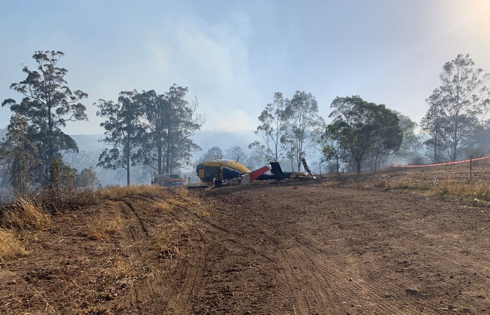 Figure 1: Aircraft prior to recovery – looking at reciprocal direction of approach. The final water drop occurred beyond the fuselage where the smoke is rising. Source: Operator