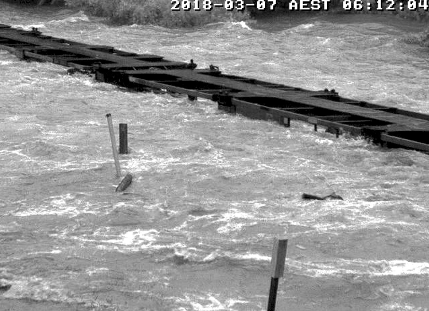 Figure 5: Empty container wagons behind train 6792’s locomotive, standing on the flooded Little Banyan Creek rail bridge.
Source: QR.