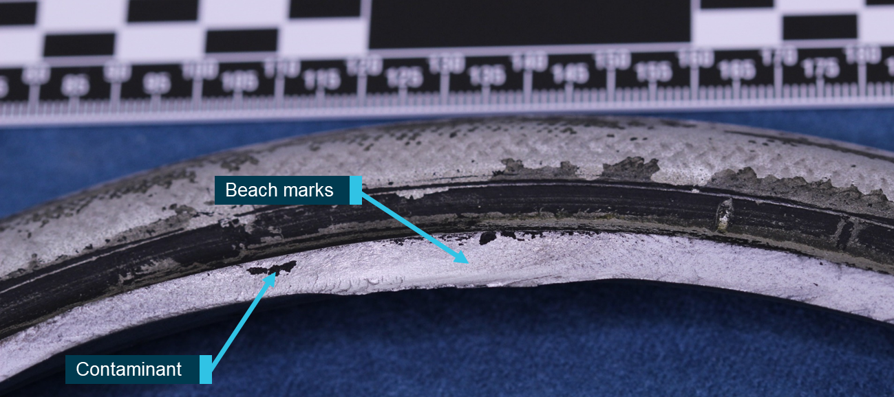 Figure 4: Magnified view of fatigue area showing crack progression along the bead seat and evidence of tyre contamination on the fracture surface.Source: ATSB