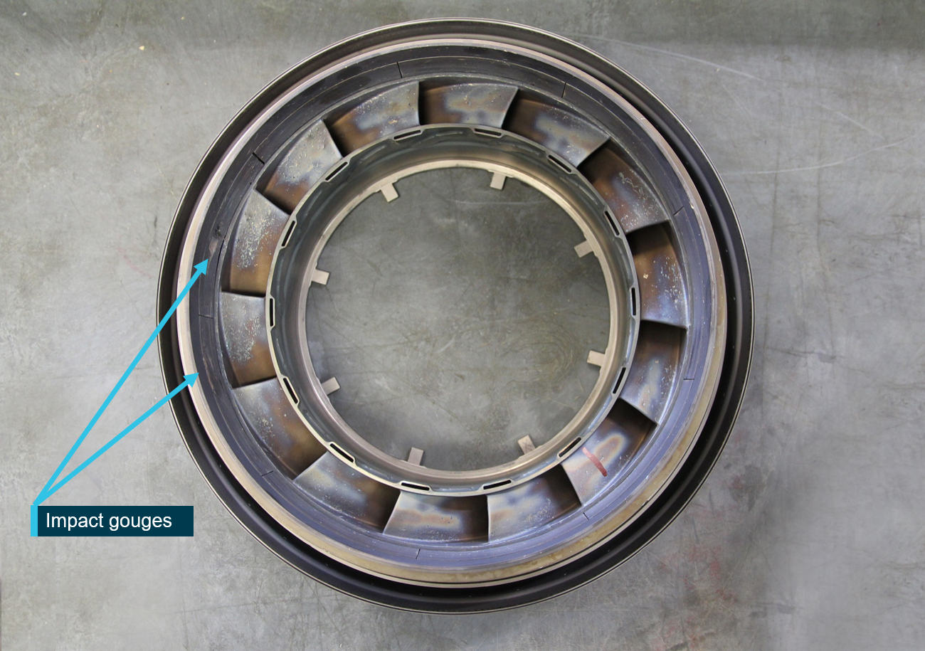 Figure 10: Compressor turbine vane ring assembly, view of the downstream face with gouge damage (labelled).CT vane ring manufacturing identifiers: (part number) 3029051, (serial number) 931E, (work order) WO 0452R16, (flow class) CL 6.25, (major repair specification) STI 72-50-254, (repair authority) STI 02-0356 Image source: ATSB