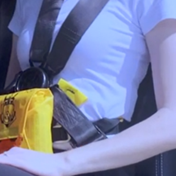 Passenger wearing a pouch-style constant wear lifejacket and multipoint seatbelt