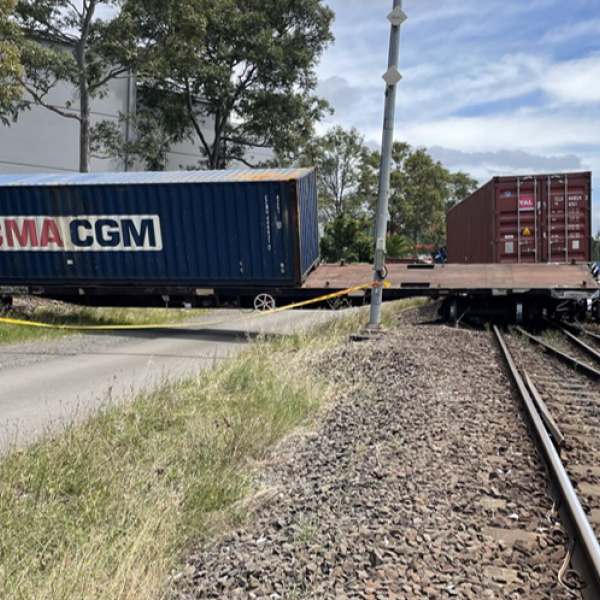 View of a wagon at right angles to track that is touching a building adjacent to rail corridor at accident site Port Botany.