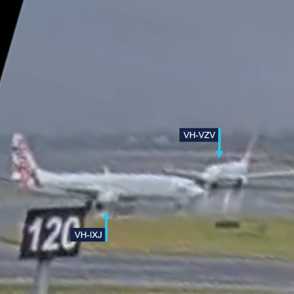 A still image from Sydney Airport CCTV showing VH-IXJ passing in front of VH-VZV