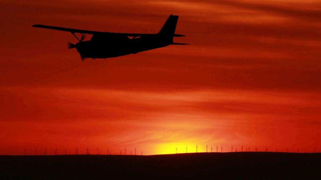 Plane flying at sunset