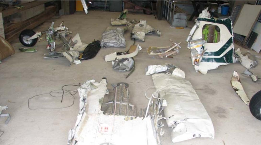 Aircraft wreckage on a hangar floor.
