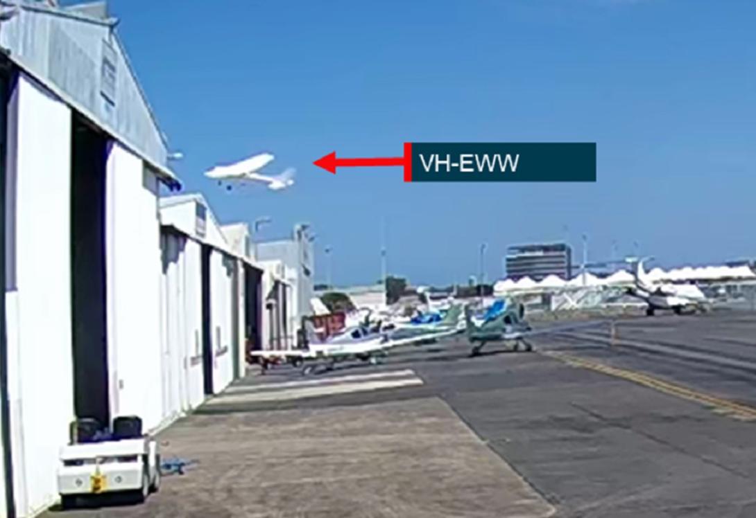 Image from CCTV footage showing VH-EWW passing close above hangars