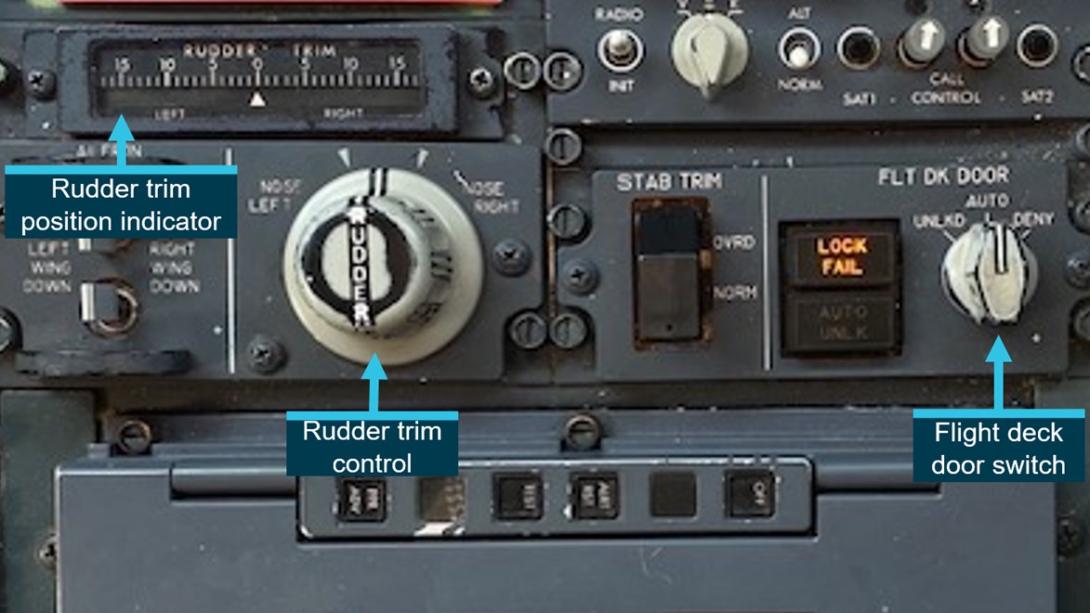 Rudder trim and door lock switch on the aisle stand of a Virgin Australia B737 aircraft.