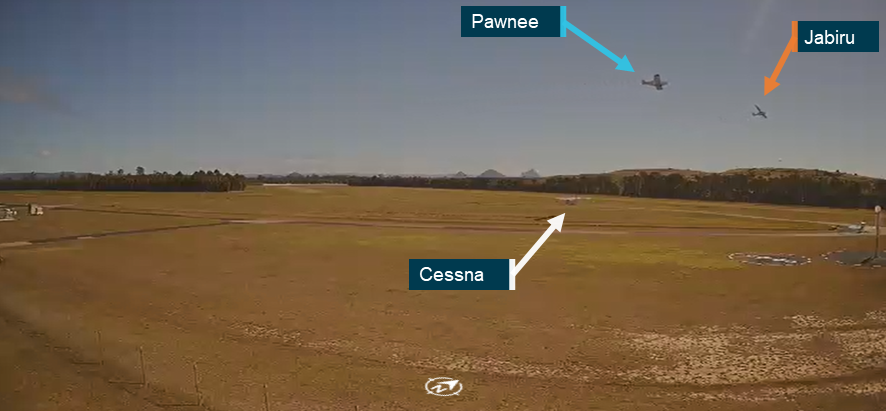 CCTV footage showing the Pawnee and Jabiru both climbing above Caboolture Airfield on converging tracks. The Cessna is shown taxiing, having already crossed runway 06.