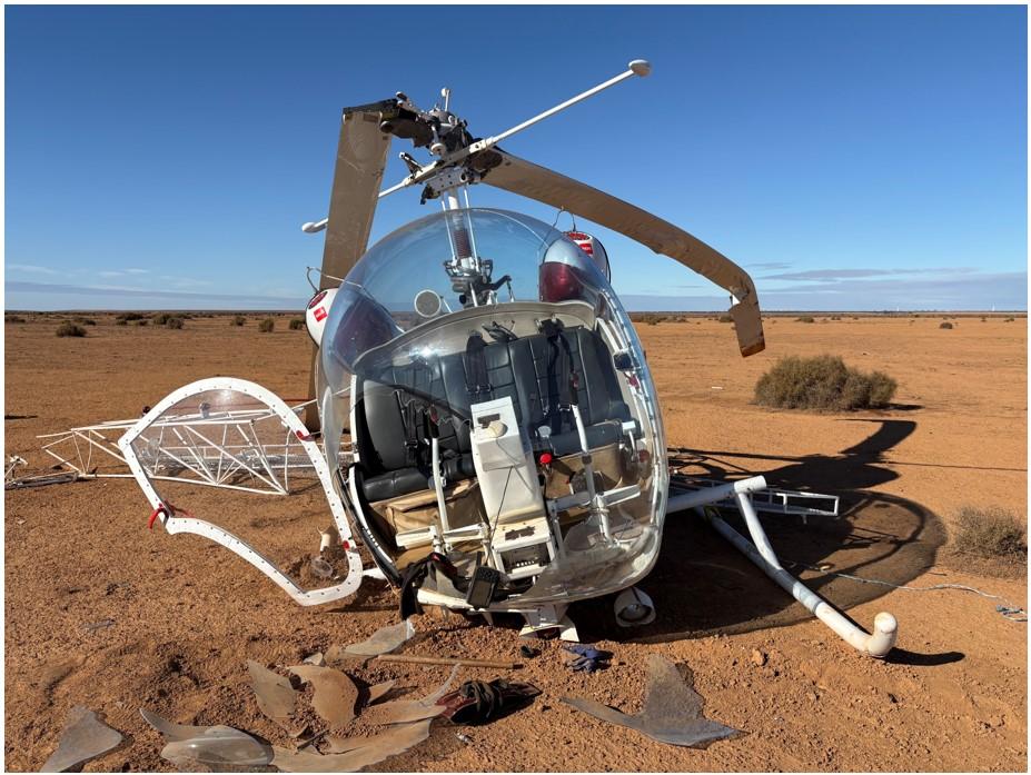 Bell 47 picture taken from in front of helicopter after landing, with broken right skid and ruptured windscreen bubble.