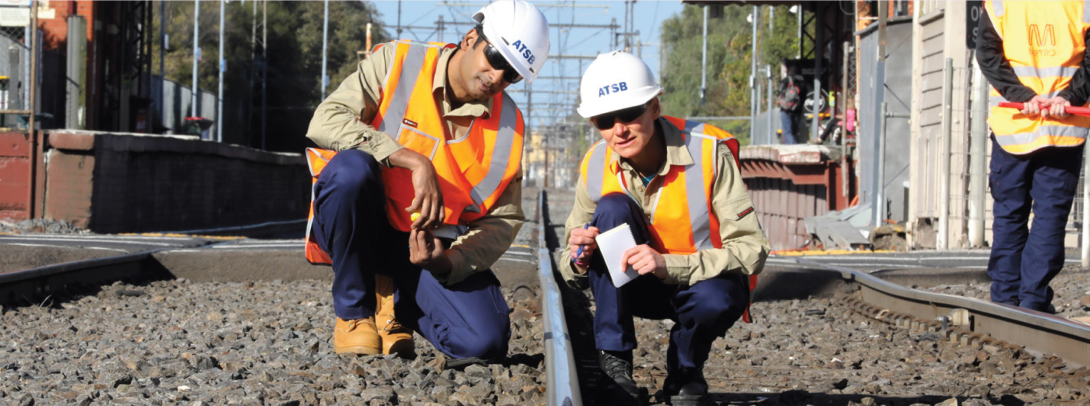 Two investigators looking at train wreckage