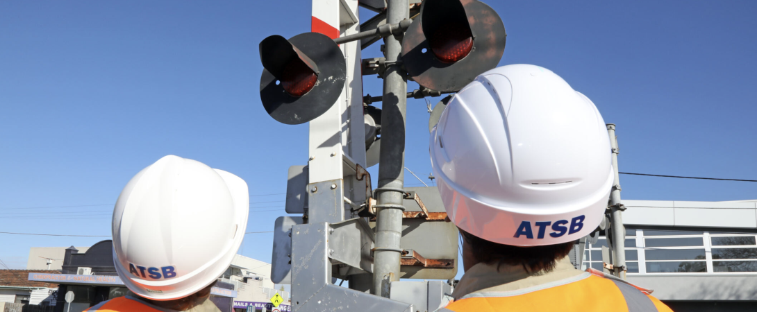 Two investigators looking at a level crossing signal during an investigation.
