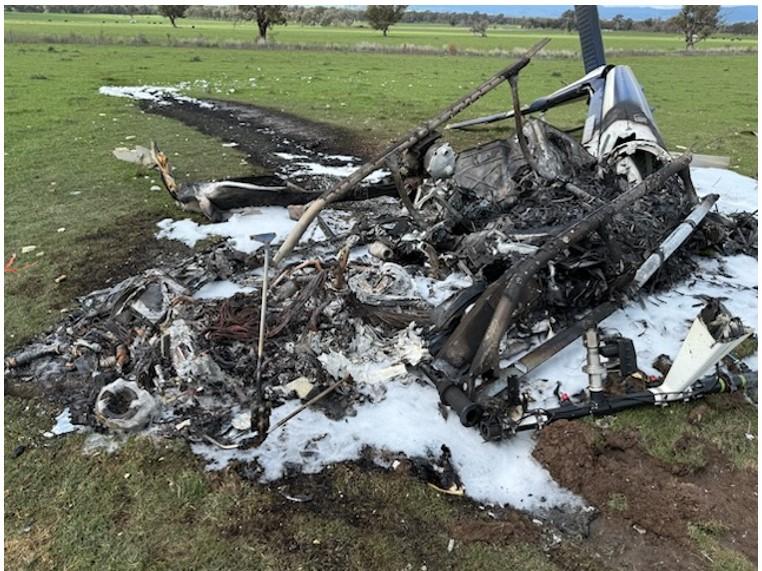 This image shows the post-impact damage to the helicopter, destroyed by fire.
